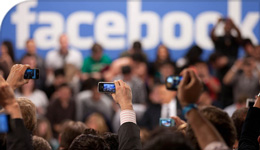 Photo of people holding phones overhead taking picture of distant Facebook stage | 2018-06-07